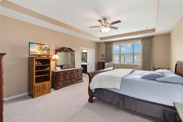 bedroom with carpet floors, a raised ceiling, baseboards, and a ceiling fan