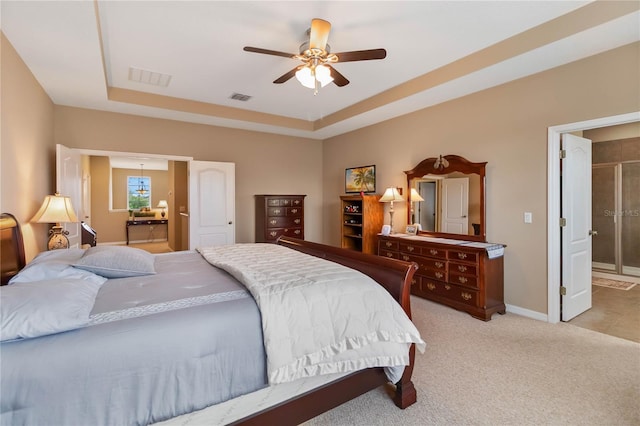 bedroom with light carpet, a raised ceiling, visible vents, and baseboards