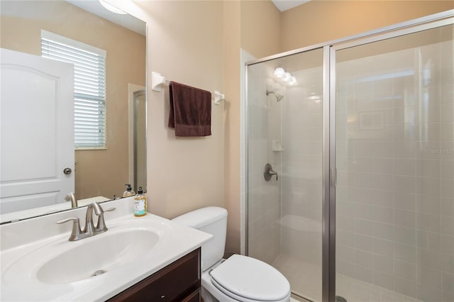 full bathroom featuring vanity, a shower stall, and toilet