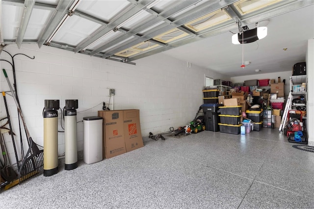 garage with a garage door opener and concrete block wall