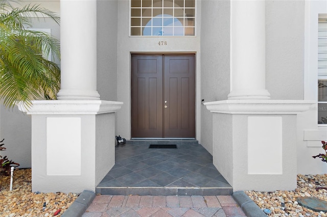 doorway to property featuring stucco siding