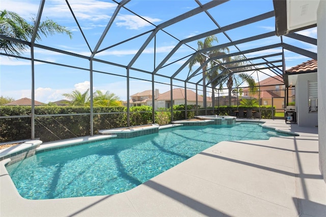 view of swimming pool with glass enclosure, a pool with connected hot tub, and a patio