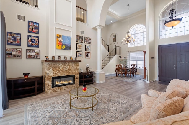 living room with visible vents, decorative columns, baseboards, and wood finished floors