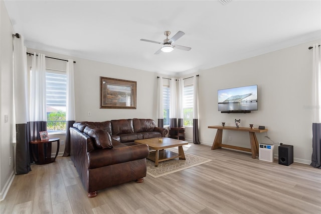 living room featuring ceiling fan, light wood-type flooring, and baseboards