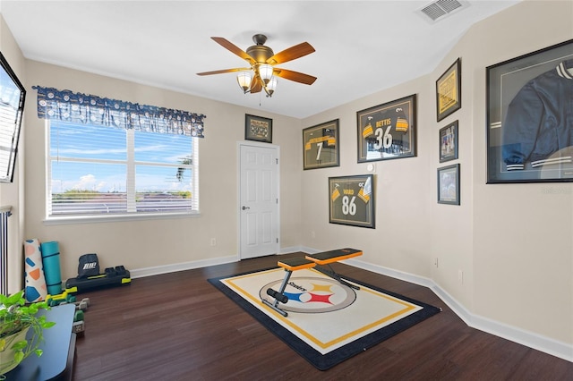 recreation room featuring a ceiling fan, visible vents, baseboards, and wood finished floors