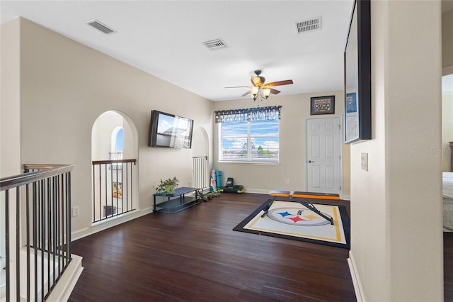 workout room featuring baseboards, visible vents, and wood finished floors