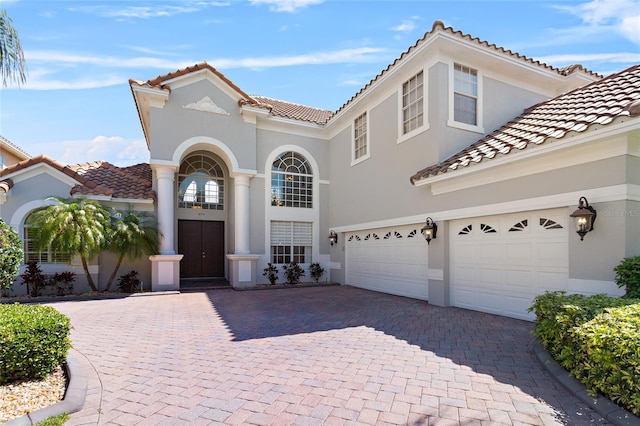 mediterranean / spanish-style home with decorative driveway and stucco siding