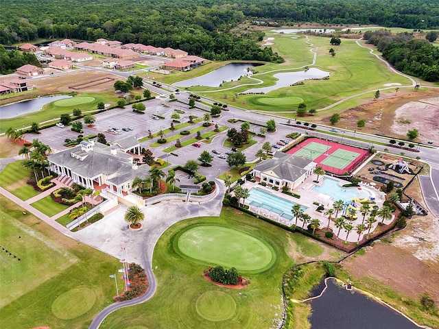 birds eye view of property with golf course view and a water view