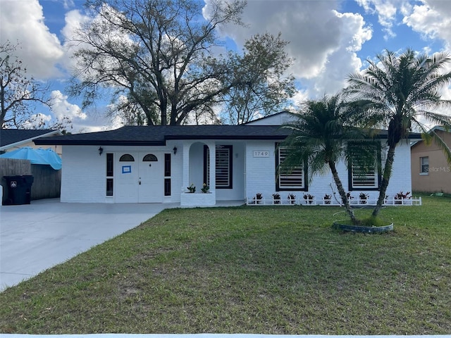 single story home with brick siding, driveway, a front lawn, and fence