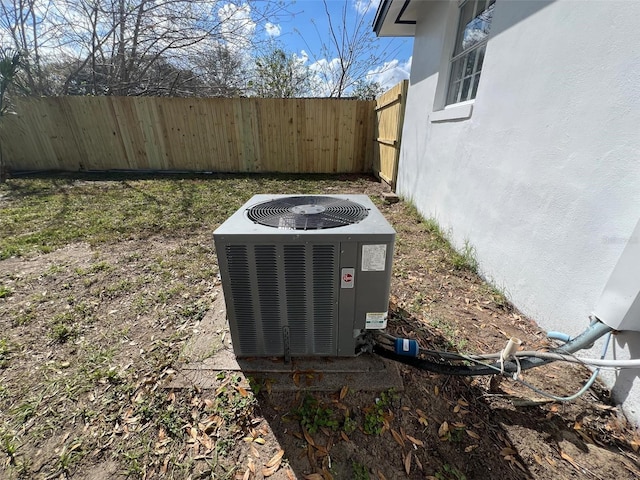 details featuring a fenced backyard, central AC, and stucco siding