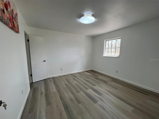 spare room with wood finished floors and baseboards