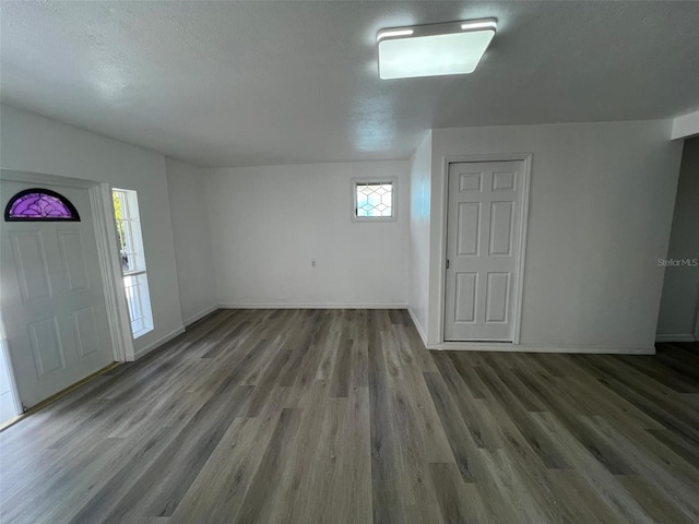 entrance foyer with a textured ceiling, baseboards, and wood finished floors