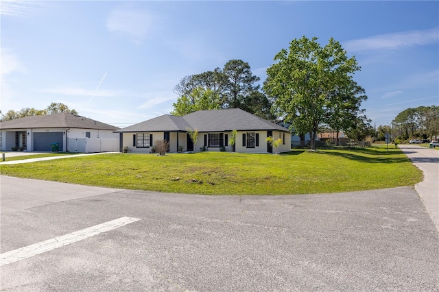 single story home with a garage, fence, and a front lawn