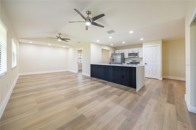 2931 Chilton St, Deltona, FL 32738 - kitchen with visible vents, light wood-style flooring, stainless steel appliances, light countertops, and white cabinetry
