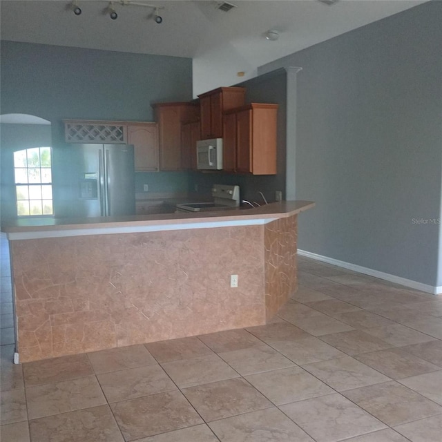 kitchen with white microwave, lofted ceiling, fridge with ice dispenser, a peninsula, and electric range