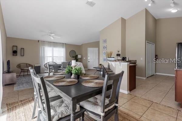 dining area with light tile patterned flooring, ceiling fan, and baseboards