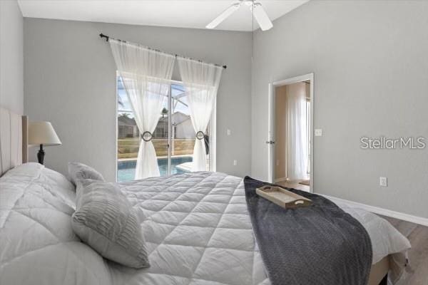 bedroom featuring access to exterior, lofted ceiling, a ceiling fan, wood finished floors, and baseboards