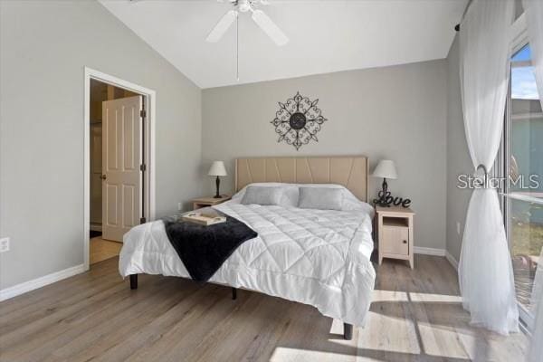 bedroom featuring lofted ceiling, a ceiling fan, baseboards, and wood finished floors