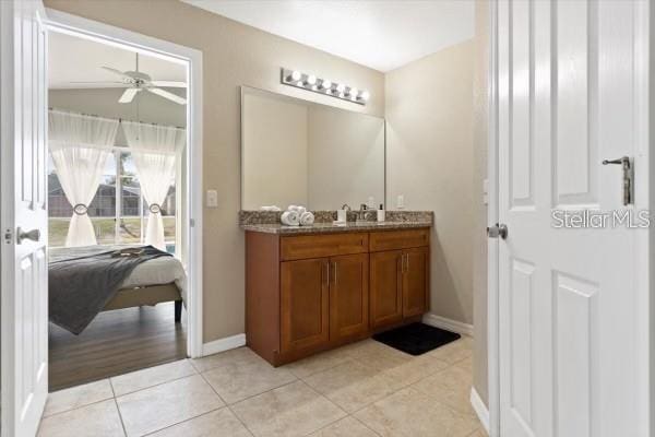 bathroom featuring ensuite bathroom, ceiling fan, vanity, tile patterned flooring, and baseboards