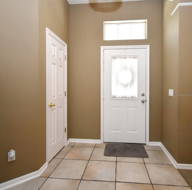 entrance foyer featuring light tile patterned flooring and baseboards