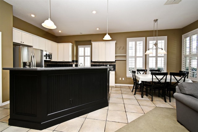 kitchen featuring dark countertops, white cabinets, appliances with stainless steel finishes, and a sink