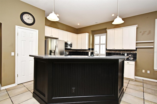 kitchen featuring decorative light fixtures, tasteful backsplash, appliances with stainless steel finishes, and white cabinetry