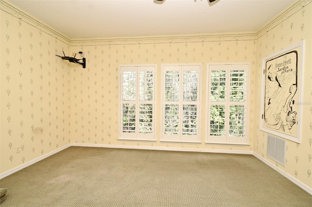 carpeted spare room with visible vents, baseboards, a healthy amount of sunlight, and wallpapered walls