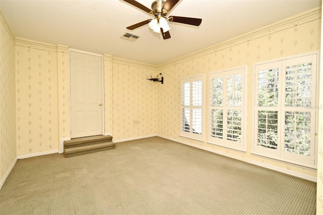 carpeted empty room with visible vents, baseboards, and wallpapered walls