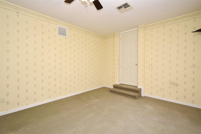 unfurnished room with wallpapered walls, visible vents, and carpet floors