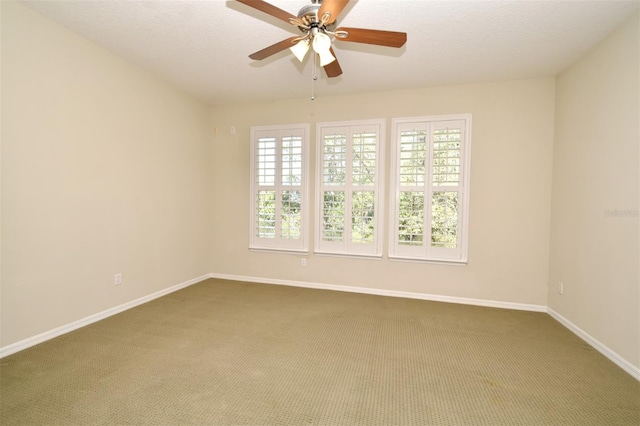 spare room with carpet flooring, a textured ceiling, a ceiling fan, and baseboards