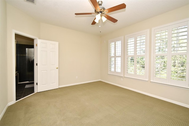 unfurnished room featuring baseboards, carpet floors, a textured ceiling, and ceiling fan