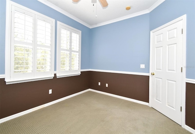 empty room featuring carpet flooring, baseboards, ceiling fan, and ornamental molding