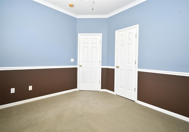 unfurnished bedroom with crown molding, carpet, and baseboards