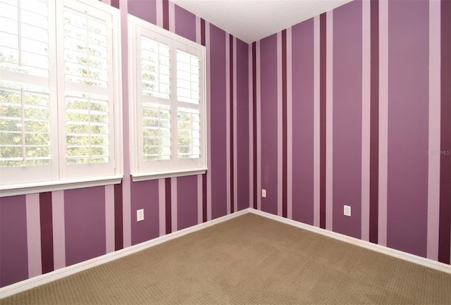 empty room with baseboards, carpet floors, and wallpapered walls