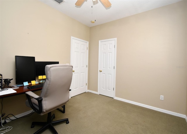 carpeted office with visible vents, baseboards, and a ceiling fan