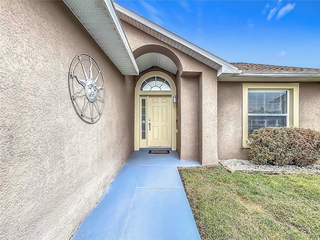 doorway to property featuring stucco siding