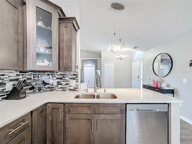 kitchen featuring light countertops, decorative backsplash, a sink, dishwasher, and a peninsula