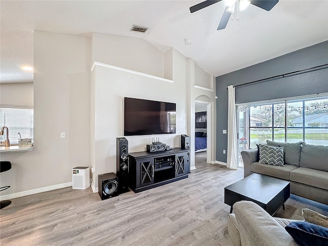 living room with visible vents, a ceiling fan, vaulted ceiling, wood finished floors, and baseboards