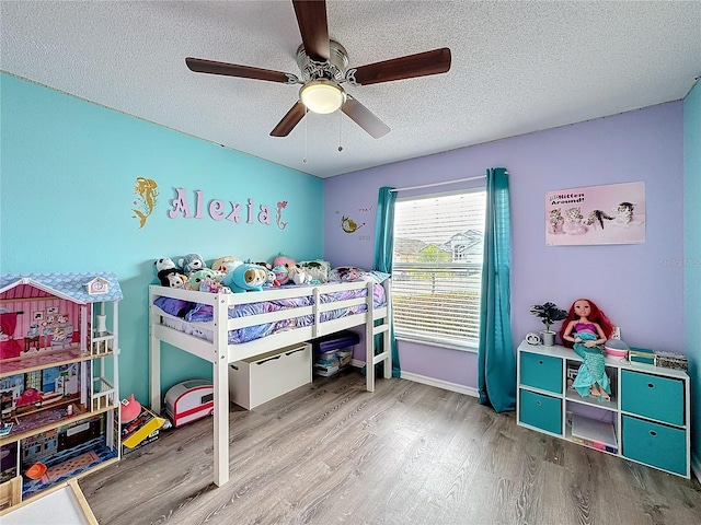 bedroom with baseboards, a textured ceiling, a ceiling fan, and wood finished floors