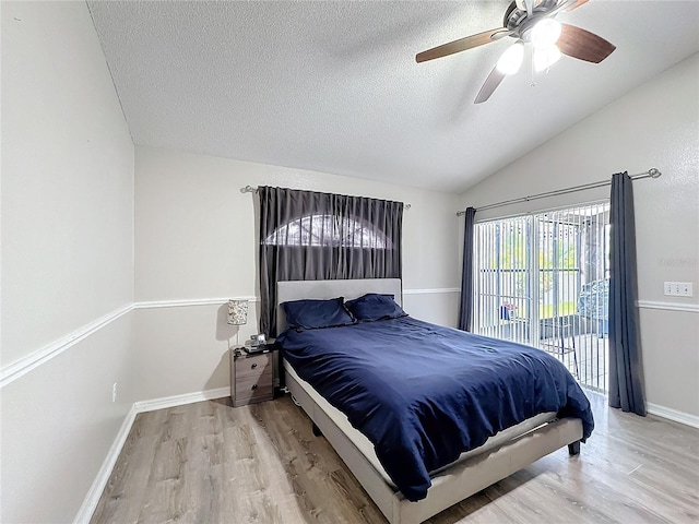 bedroom with light wood finished floors, baseboards, lofted ceiling, access to outside, and a textured ceiling