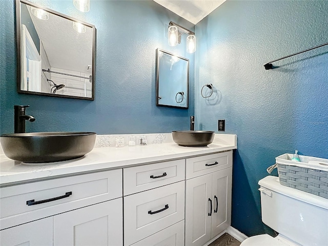 bathroom featuring a textured wall, a sink, and toilet