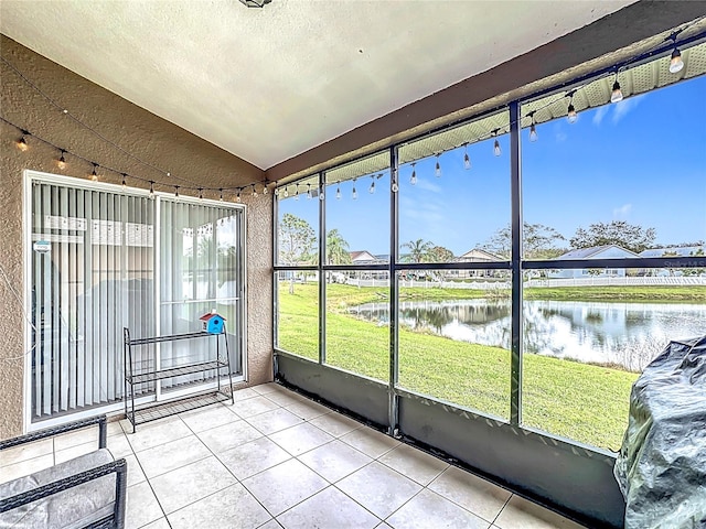 sunroom / solarium with lofted ceiling and a water view