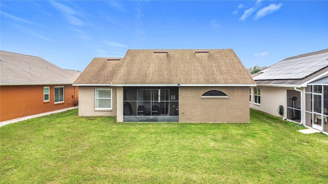 rear view of house with a lawn and stucco siding