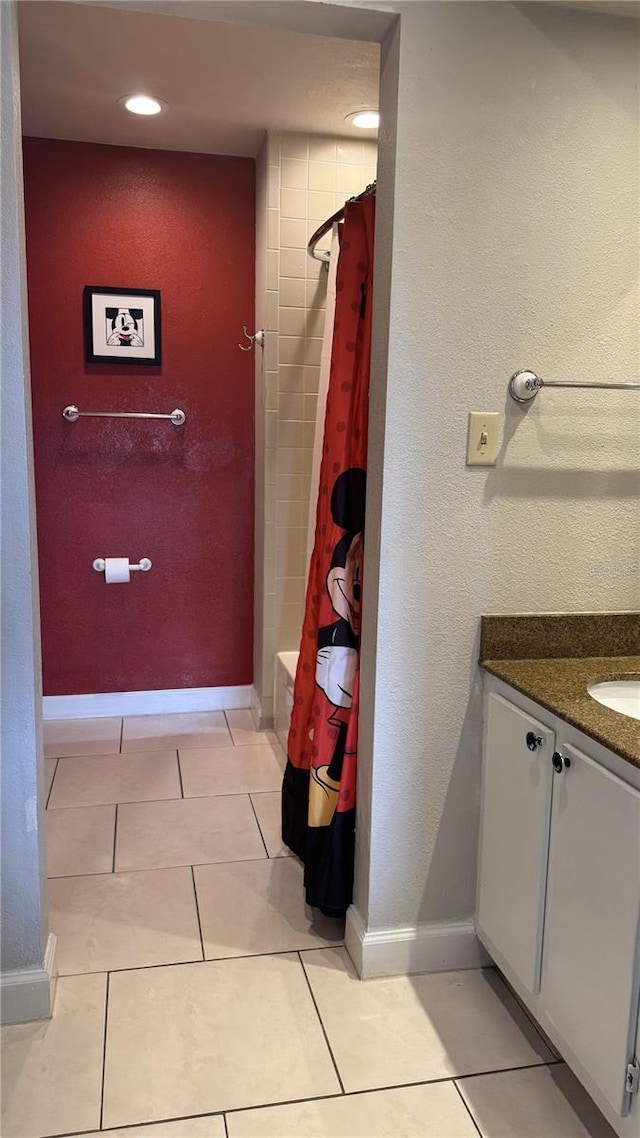 bathroom with vanity, baseboards, and tile patterned floors