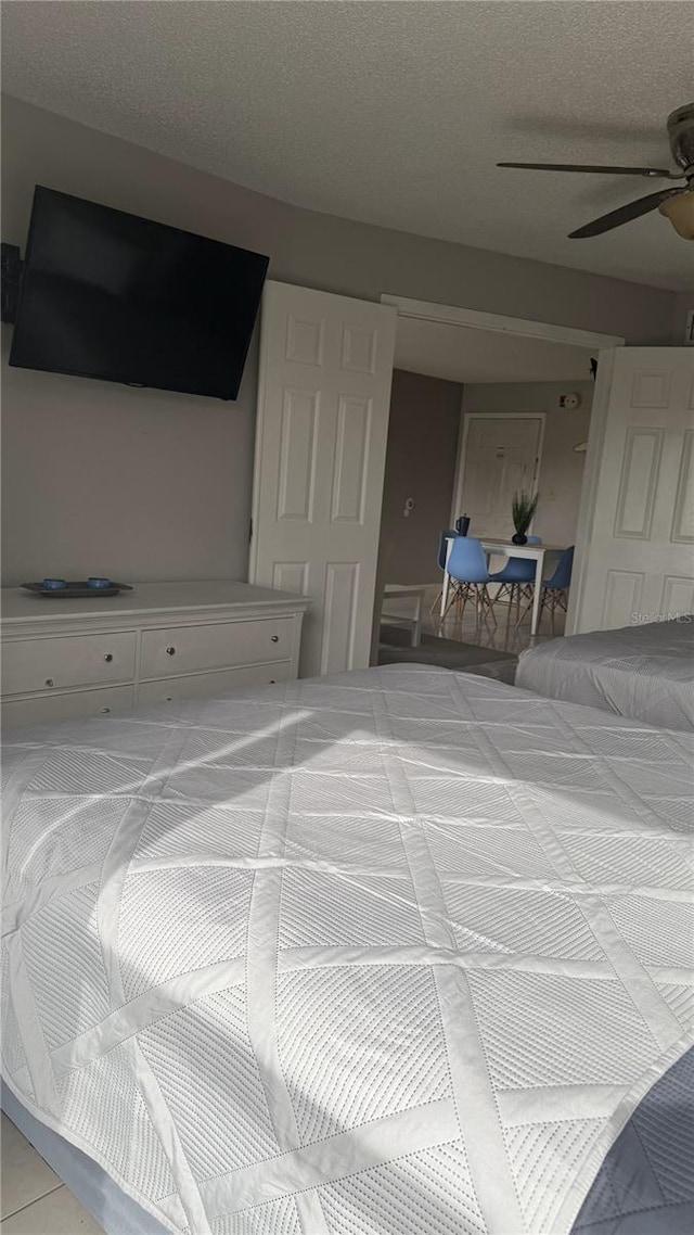 bedroom featuring a textured ceiling and a ceiling fan