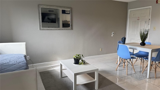 living room featuring tile patterned flooring, visible vents, and baseboards