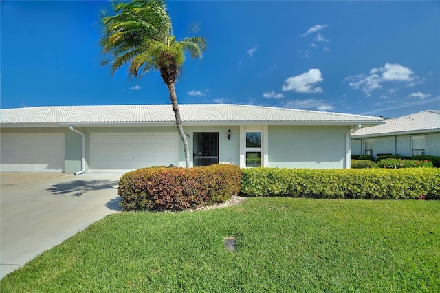 single story home featuring an attached garage, a tile roof, driveway, stucco siding, and a front yard