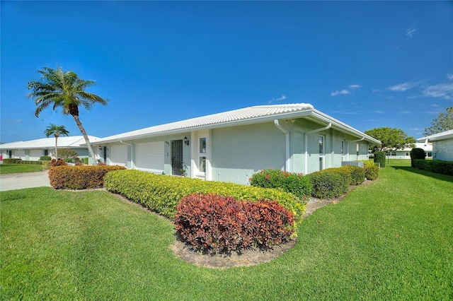 view of property exterior featuring a garage, a yard, and stucco siding