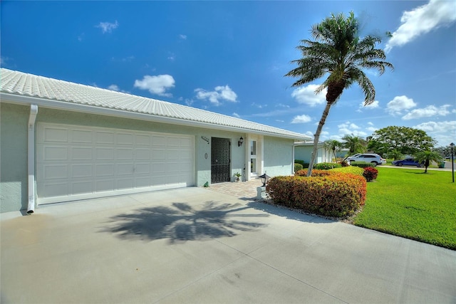 single story home featuring stucco siding, an attached garage, driveway, a tiled roof, and a front lawn