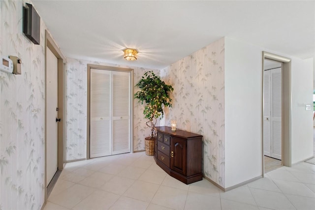 interior space featuring baseboards and wallpapered walls